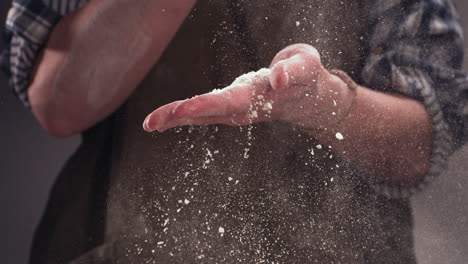 SUPER-SLOW-MOTION-Woman-chief-cook-clapping-and-sprinkling-flour-over-dough-on-table.-Shot-with-high-speed-camera-at-720-FPS